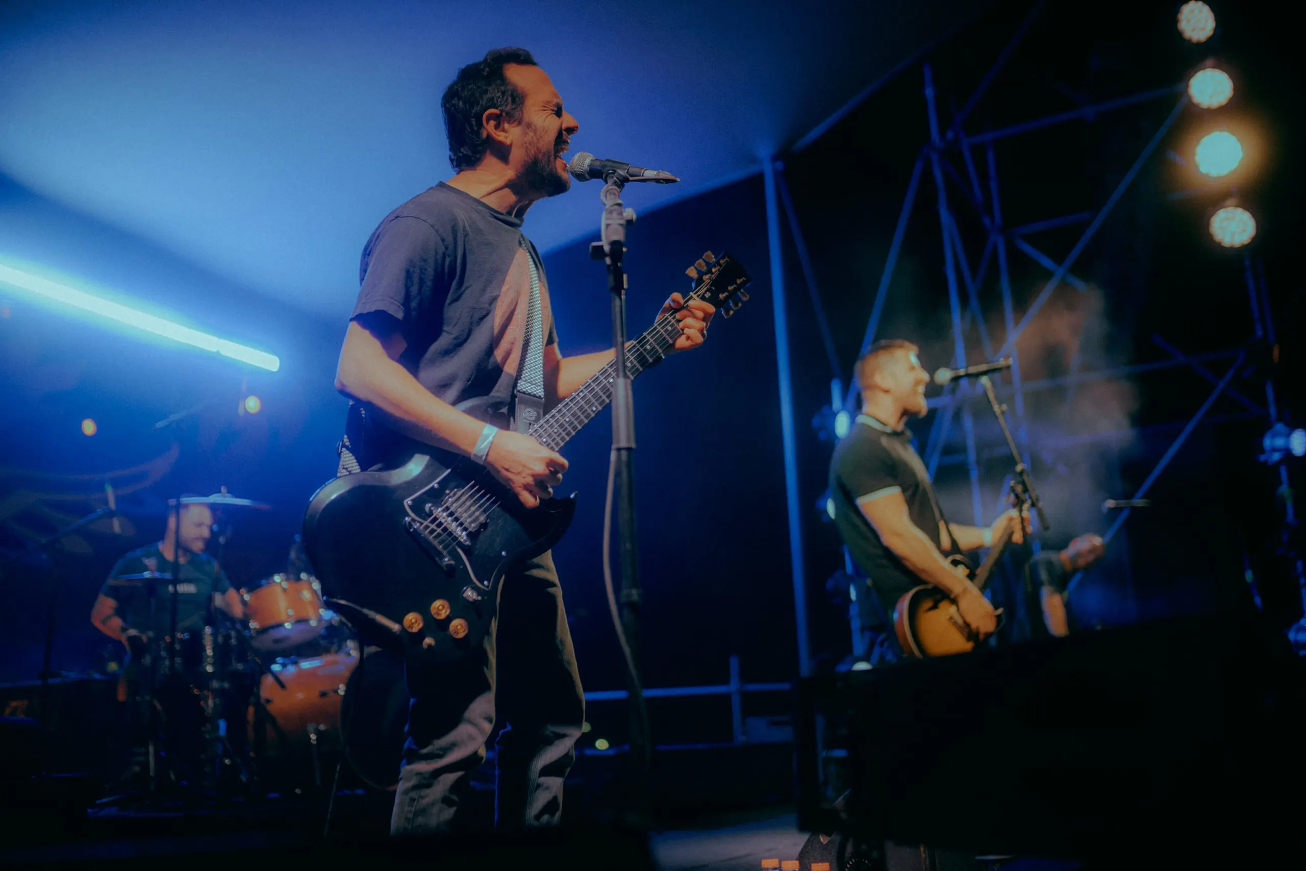 The City Revival on a blue-lit stage, two guitarists singing, the drums behind them